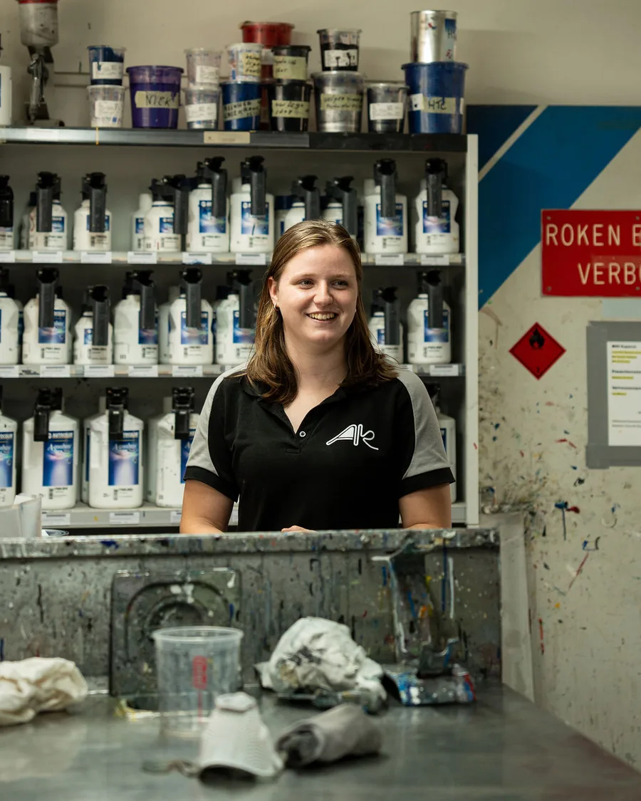 Medewerker van Autospuitbedrijf Kuperus aan de balie van het mengcentrum