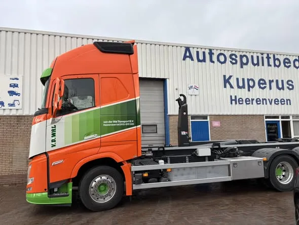 Volvo met belettering voor het pand van Kuperus